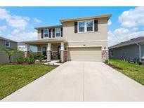 Beautiful two-story house with stone accents and a two-car garage at 8861 Forge Breeze Loop, Wesley Chapel, FL 33545