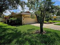 Single-story home with attached garage and landscaped yard at 3582 Fairway Forest Dr, Palm Harbor, FL 34685
