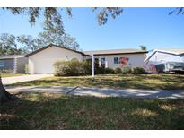 Single-story home with attached garage and landscaped lawn at 10698 117Th Way, Largo, FL 33778