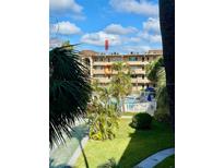 View of community pool, shuffleboard courts, and lush landscaping at 2525 W Bay Dr # B32, Largo, FL 33770
