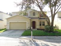 Two-story house with attached garage and landscaped yard at 10605 Marsanne Pl, Riverview, FL 33578