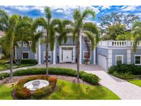 Stately two-story home with white columns, mature palms, and a circular driveway at 45 Adalia Ave, Tampa, FL 33606