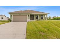 Newly built home with green exterior and driveway at 10061 Gulfstream Blvd, Englewood, FL 34224