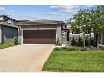 Charming home featuring a well-manicured lawn, driveway, and two-car garage at 281 Villa Corte Dr, Lutz, FL 33549