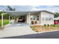 Tan mobile home with carport at 7154 El Meyers St, Zephyrhills, FL 33541