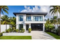 Modern two-story home featuring a black garage door, balcony, and lush tropical landscaping at 2203 Glenwood, Tampa, FL 33602