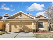 Charming home featuring a well-maintained lawn, two-car garage, and neutral color palette under a sunny sky at 20308 Oak Key Ct, Tampa, FL 33647