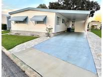 Mobile home with covered carport and well-maintained landscaping at 9790 66Th N St # 196, Pinellas Park, FL 33782