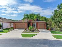 Two-story house with a two-car garage, palm trees, and a landscaped front yard at 31982 Bourneville Ter, Wesley Chapel, FL 33543
