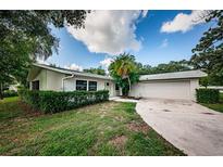 Light-colored house with attached garage and neatly trimmed hedges at 1001 Chinaberry Rd, Clearwater, FL 33764
