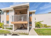 Two-story condo building features a private covered balcony, walkway, and manicured landscaping at 621 99Th N Ave # 102, St Petersburg, FL 33702