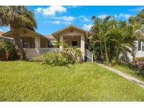 Tan house with light brown trim, white porch railings, and lush green lawn at 927 19Th S Ave, St Petersburg, FL 33705