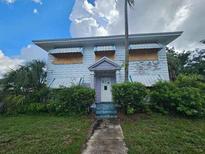 Older two-story house requiring renovations, featuring boarded windows at 2220 18Th S St, St Petersburg, FL 33712