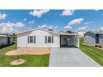 Cute and cozy manufactured home with a carport and landscaped yard at 37601 Neukom Ave, Zephyrhills, FL 33541