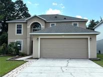 Two-story house with neutral siding, a two-car garage, and a manicured lawn at 5239 Tummel Ct, Wesley Chapel, FL 33545