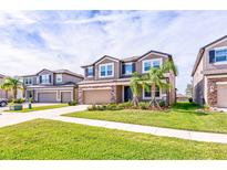 Two-story house with a two-car garage and landscaped front yard at 11321 Alachua Creek Ln, Riverview, FL 33579