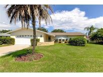 House exterior with palm tree, lawn, and two-car garage at 1745 Harbor W Cir, Largo, FL 33770