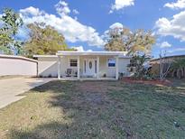 Inviting single-story home featuring a charming front porch and well-maintained lawn under a bright sky at 1155 7Th N St, Safety Harbor, FL 34695