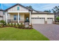 Charming home featuring a manicured lawn, covered porch, and a three-car garage at 4638 Southern Valley Loop, Brooksville, FL 34601