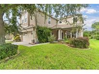 Charming two-story home features lush green lawn, attached two car garage and traditional curb appeal at 7127 Forest Mere Dr, Riverview, FL 33578