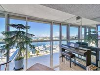 Bright living room with expansive windows offering stunning views of the harbor and a grand piano at 800 S Gulfview Blvd # 903, Clearwater Beach, FL 33767