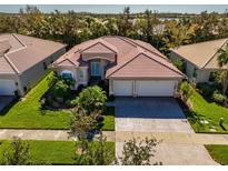 Aerial view of a two-story house with a three-car garage and landscaped yard at 4977 Sapphire Sound Dr, Wimauma, FL 33598