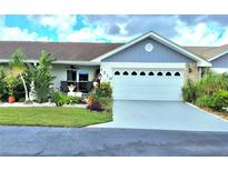 View of the garage and manicured front yard at 1210 Lakehouse Ct # 3, Sun City Center, FL 33573