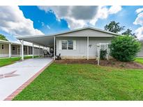 Mobile home with carport, star-shaped driveway, and landscaping at 36750 Kimela Ave, Zephyrhills, FL 33542
