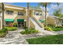 Building exterior with stairs, green awnings, and landscaping at 10823 Indian Hills Ct # 32, Seminole, FL 33777