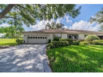 Single-story home with attached garage and landscaped yard at 2535 Lancaster Dr # 2535, Sun City Center, FL 33573