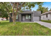 Modern gray house with a covered porch and driveway at 2604 N 29Th St, Tampa, FL 33605