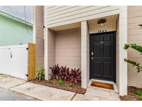 Front view of a two-story house with a black door and landscaping at 1905 E Mulberry Dr # 2, Tampa, FL 33604