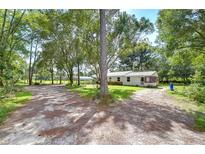 Single story home with white siding and metal roof at 7249 Berry Rd, Zephyrhills, FL 33540