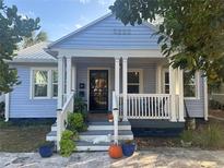 Charming bungalow home with blue siding, a welcoming front porch, and decorative landscaping at 860 19 N Ave, St Petersburg, FL 33704