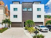 Modern two-unit building with attached garages and landscaping at 156 175Th E Ave, Redington Shores, FL 33708