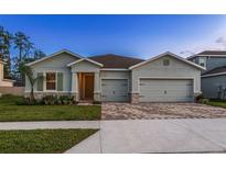 Charming single-story home featuring a spacious three-car garage and beautifully landscaped front yard at 23176 Pachino Way, Lutz, FL 33549