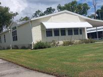 Yellow single wide manufactured home with awning and landscaped yard at 197 Philadelphia Blvd # 26, Palm Harbor, FL 34684