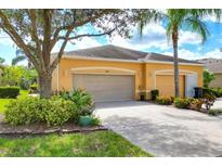 House exterior with a two-car garage and landscaped yard at 2346 Oakley Green Dr # 75, Sun City Center, FL 33573