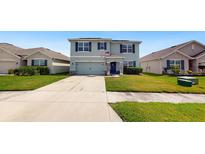 Two-story house with a gray facade and a well-maintained lawn at 2616 Garden Plum Pl, Odessa, FL 33556