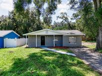 Charming single story home with gray siding and well-manicured lawn at 1709 E Sitka St, Tampa, FL 33604