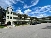 Royal Dutch condominium building, featuring a light green exterior and ample parking at 2385 Tahitian Ln # 63, Clearwater, FL 33763