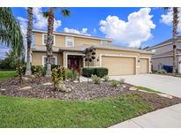 Two-story house with three car garage and landscaped yard at 5806 Candytuft Place, Land O Lakes, FL 34639
