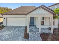 Charming single-story home showcasing a brick driveway, a one car garage and a welcoming covered entry porch at 13728 Sunlight Meadow Dr, Riverview, FL 33578