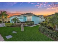 Light blue house with two-car garage and landscaping at 11413 Captiva Kay Dr, Riverview, FL 33569