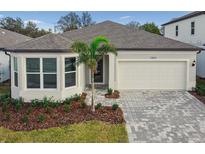 Charming single-story home features a well-manicured lawn, paver driveway, and inviting architectural details at 13808 Sunlight Meadow Dr, Riverview, FL 33578