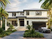 Stunning two-story home featuring a metal roof, an attached garage, and a meticulously landscaped front yard at 559 W Davis Blvd, Tampa, FL 33606