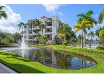 Exterior view of building with pond and landscaping at 1030 Bellasol Way # 201, Apollo Beach, FL 33572