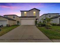 Two-story home with a white garage door and landscaped yard at 6406 Bar S Bar Trl, Zephyrhills, FL 33541