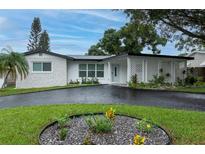 Charming one-story home featuring a brick facade, covered porch, and landscaped front yard at 11452 81St Pl, Seminole, FL 33772