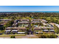 Aerial view of community with pool, tennis courts, and ocean views at 12300 Vonn Rd # 7101, Largo, FL 33774